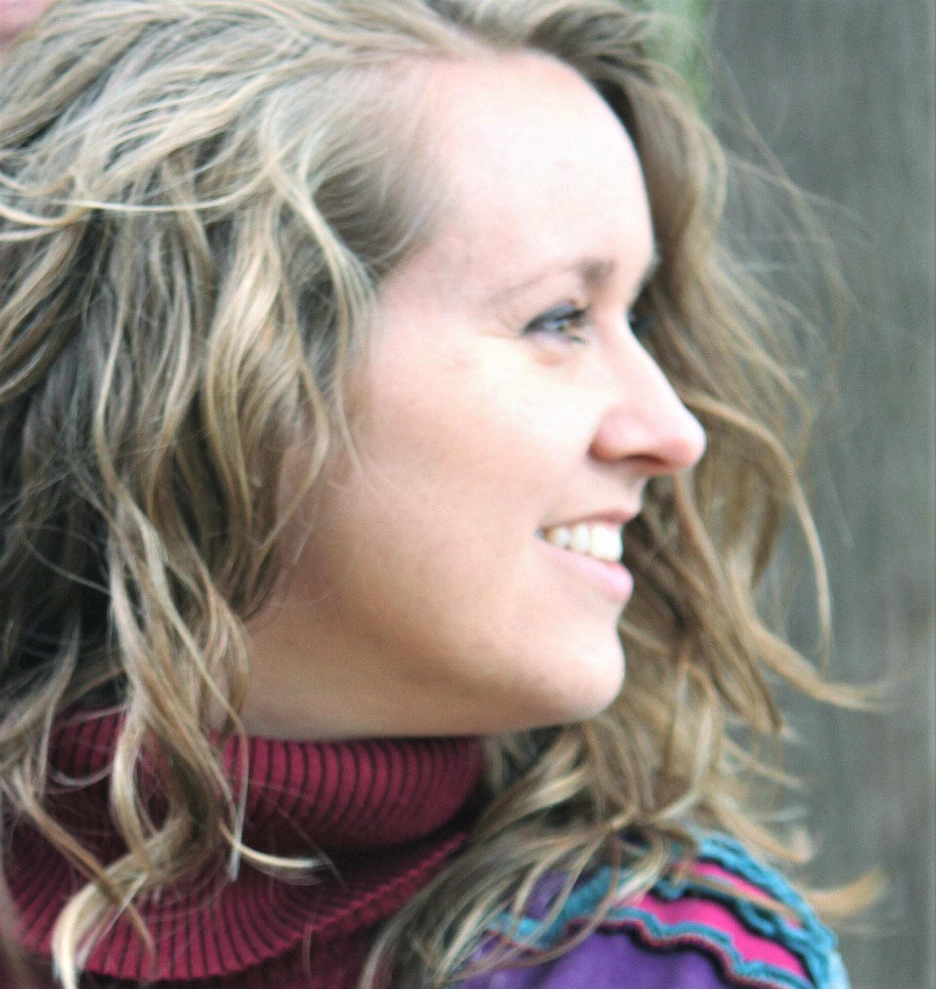 Valerie turned to the side, with wavy hair and colourful jacket